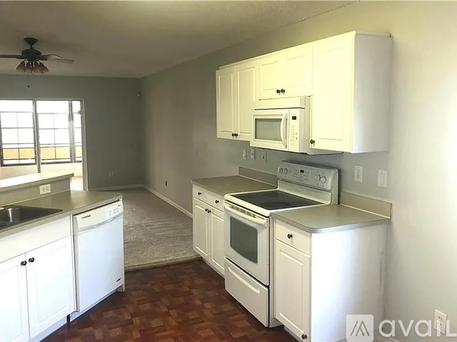 A kitchen with white cabinets and appliances.
