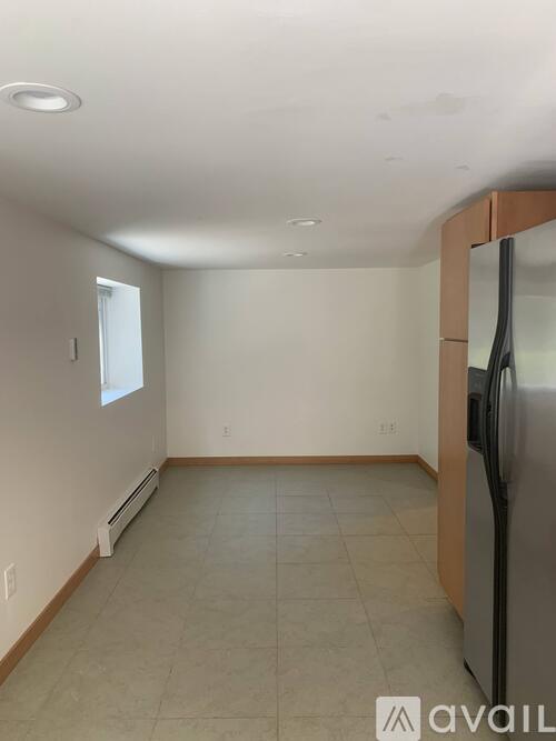 A kitchen with a refrigerator and a window.