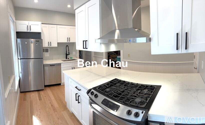 A modern kitchen with a stove top oven and a refrigerator.