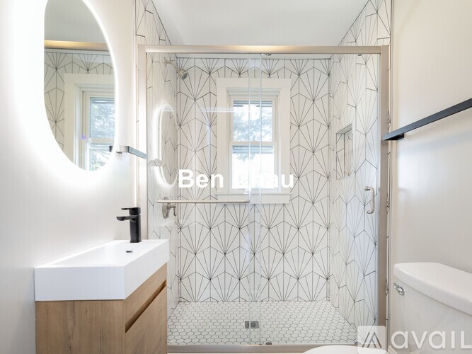 A modern bathroom with a white sink and a mirror.