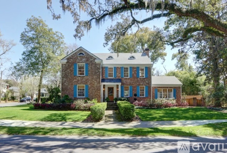A blue and white house with a tree in front.
