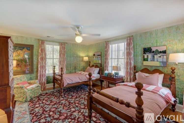 A bedroom with two beds and a ceiling fan.