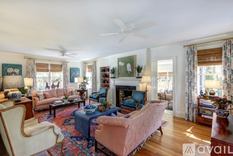 A living room with a pink sofa and a fireplace.