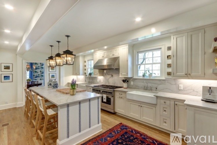 A kitchen with white cabinets and a wooden island.