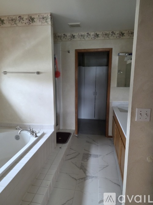 A bathroom with a tub, sink, and a shower curtain.