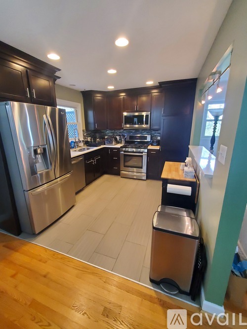 A kitchen with a refrigerator, oven, and microwave.