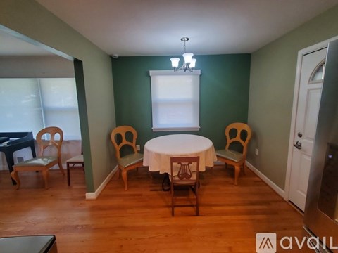 A dining room with a table and chairs.