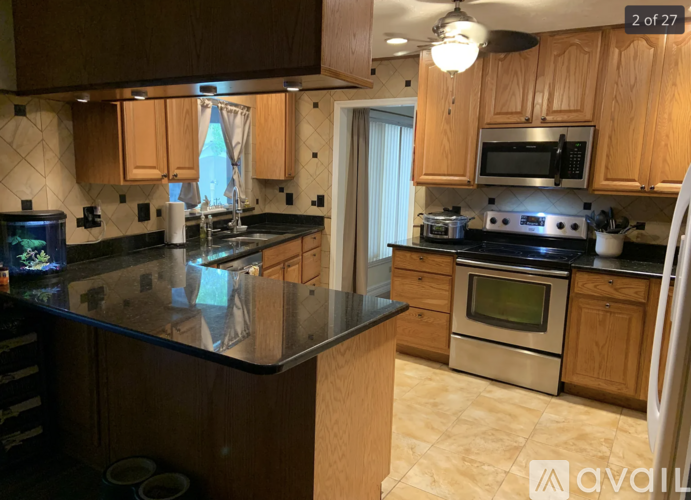 A kitchen with wooden cabinets and black countertops.