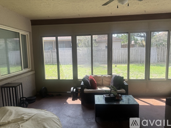 A living room with a sofa, a table, and a fan.