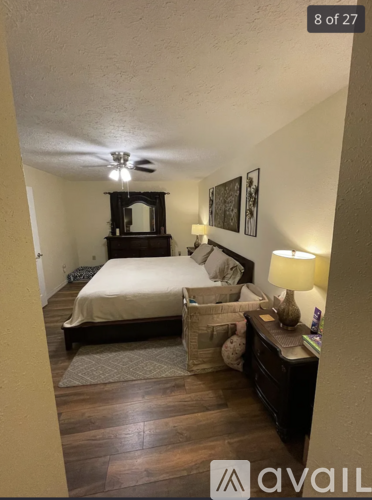 A bedroom with a bed, dresser, and ceiling fan.