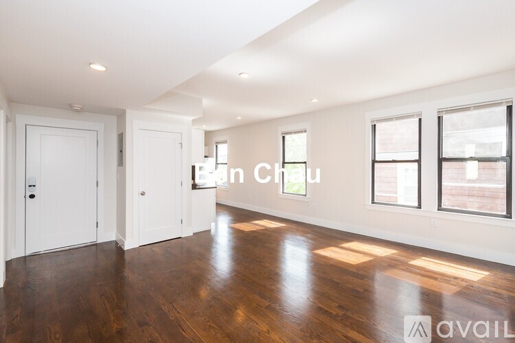 A spacious room with wooden floors and white walls.