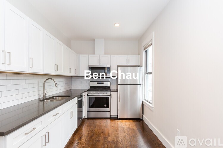 A kitchen with white cabinets and a stainless steel refrigerator.