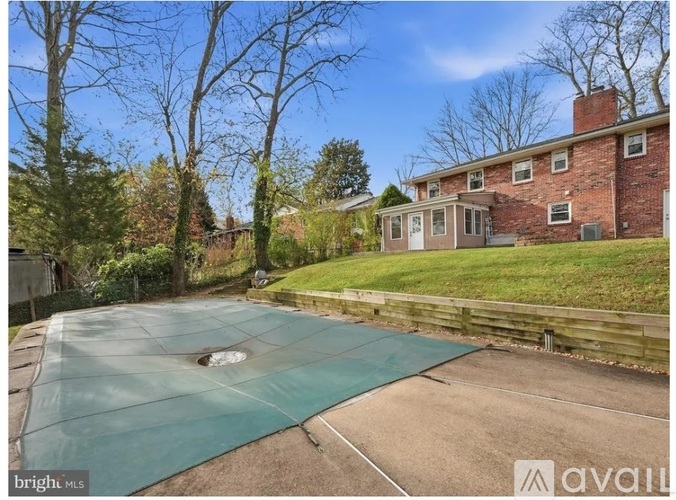 A backyard with a pool and a house in the background.