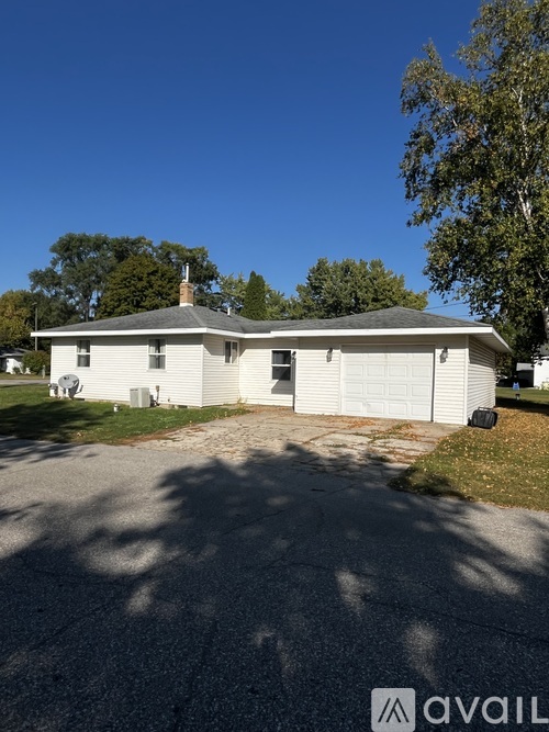 A house with a garage and a driveway in front of it.