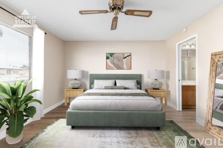 A bedroom with a bed, a ceiling fan, and a mirror.