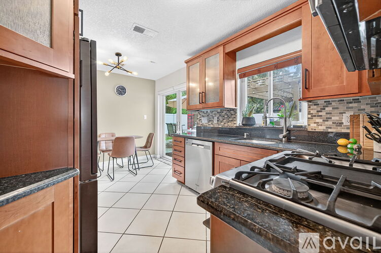 A kitchen with a stove top oven and a refrigerator.