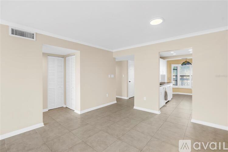 A spacious room with beige walls and a tiled floor.