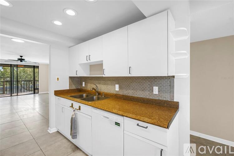 A kitchen with white cabinets and a wooden countertop.