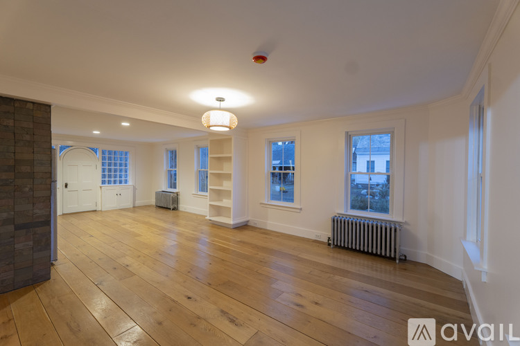 A spacious room with wooden floors and white walls.