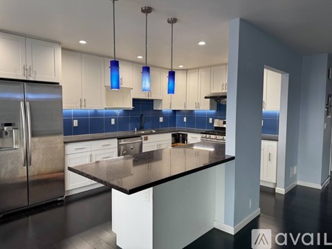 A modern kitchen with a large island and stainless steel appliances.