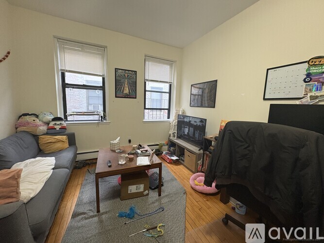 A living room with a grey couch, a coffee table, and a TV.