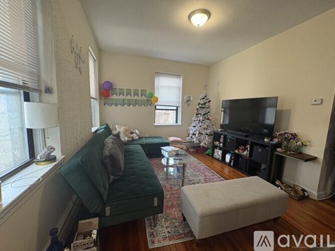A living room with a green couch and a television.