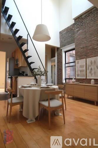 A dining room with a table set for two and a staircase.