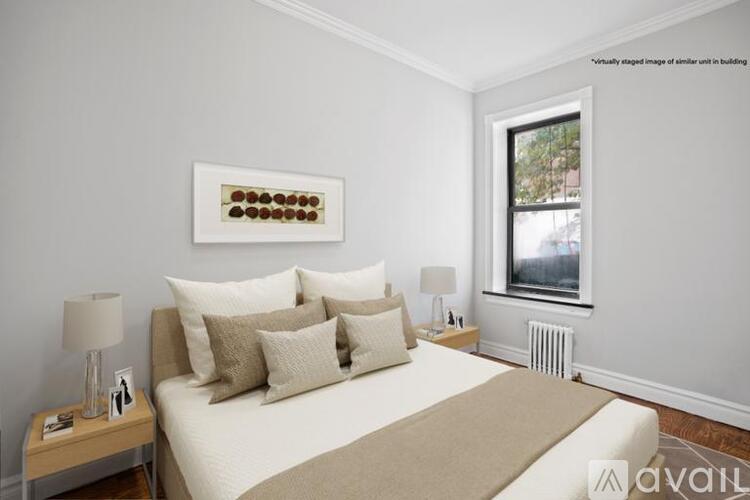 A bedroom with a bed, nightstand, and window.