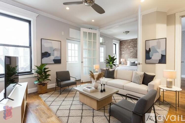 A living room with a white couch, a coffee table, and a ceiling fan.