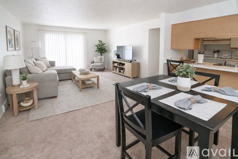 A well-lit, modern living room with a dining area and kitchenette.