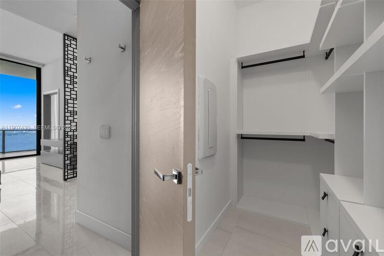 A modern kitchen with white cabinets and a wooden door.