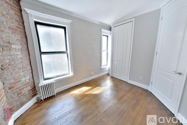 A room with a brick wall and wooden flooring.