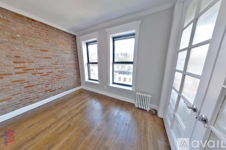 A room with a brick wall and wooden flooring.