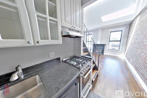 A kitchen with white cabinets and a stainless steel sink.