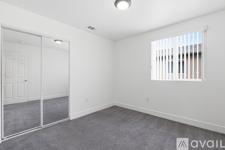A room with a sliding glass door and a window with blinds.