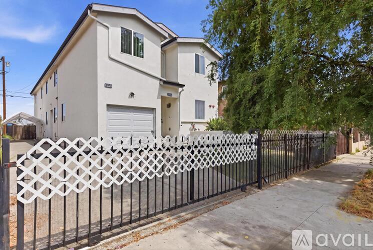 A white house with a black fence in front of it.
