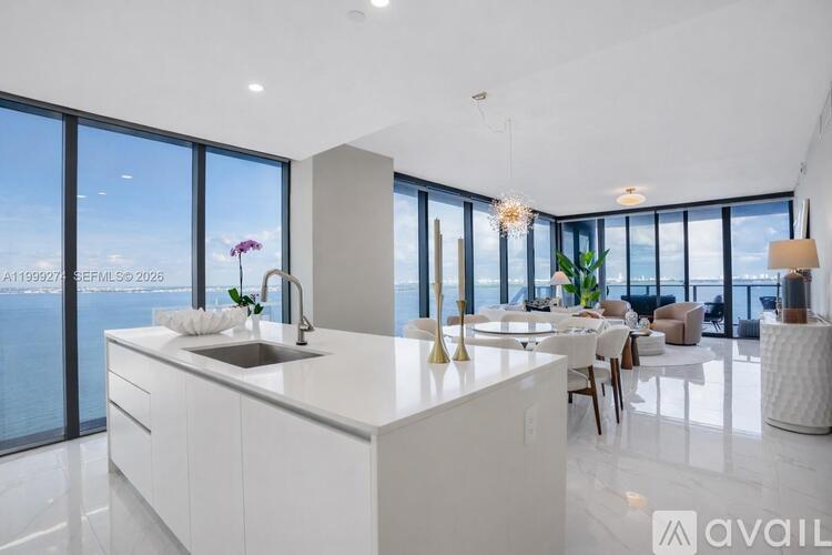 A modern kitchen with a large island and a view of the city.
