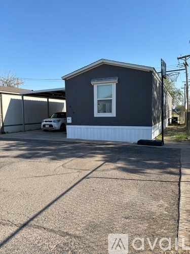 A grey house with a white garage door and a car parked in front.