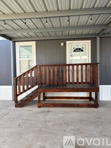 A wooden bench with a backrest is on a porch.