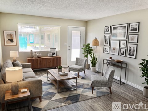 A well-lit living room with a grey sofa, a wooden coffee table, and a glass table with a plant on it.