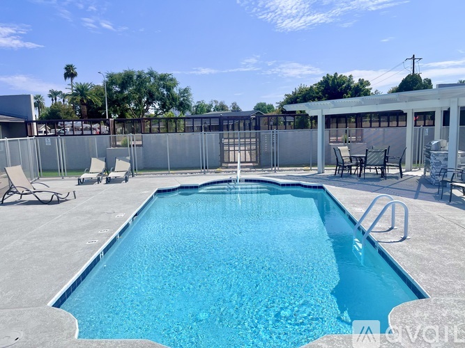 A swimming pool with a fence and chairs around it.