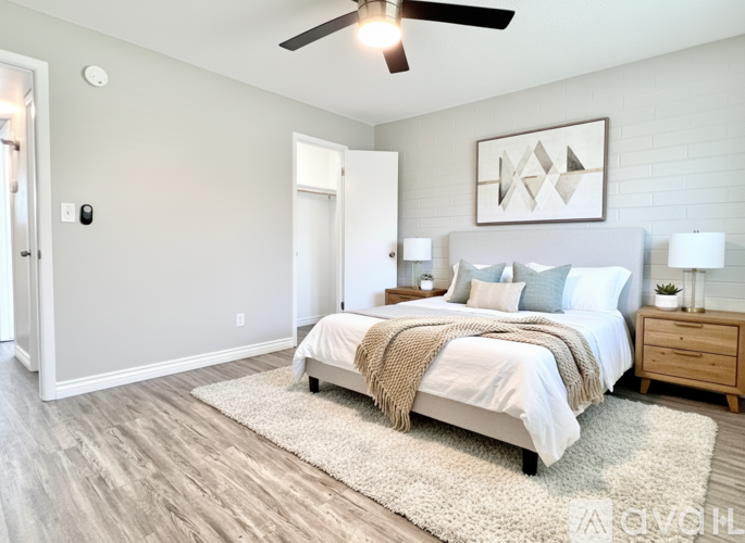 A bedroom with a bed, nightstand, and a ceiling fan.