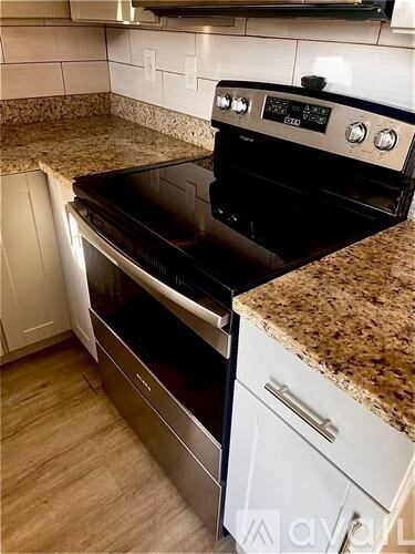 A black stove top oven with a digital display and knobs is installed in a kitchen.