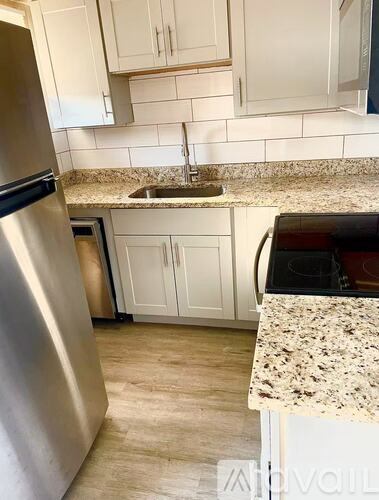 A kitchen with a granite countertop and stainless steel appliances.