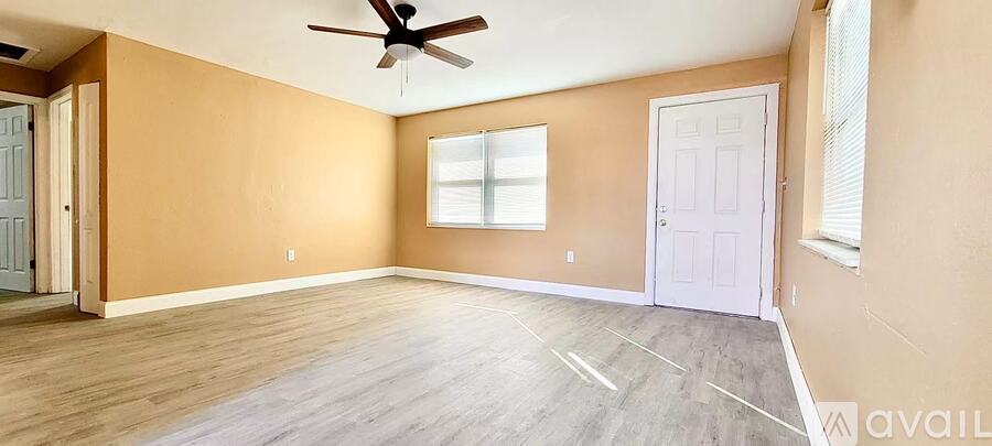 A room with a ceiling fan and two doors.
