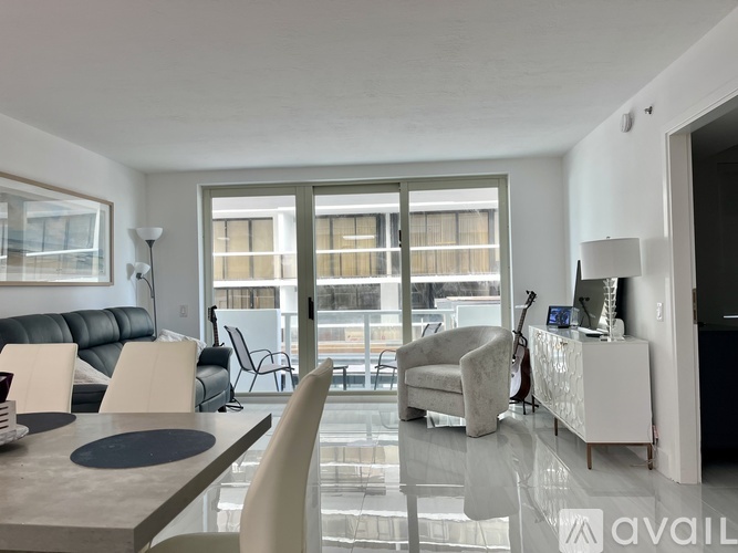A modern living room with a glass table and leather sofa.