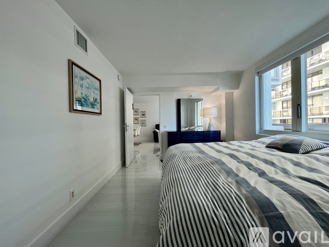 A bedroom with a large bed and a painting on the wall.