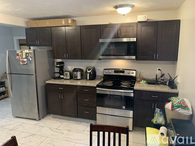 A kitchen with a refrigerator, oven, and microwave.
