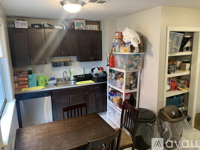 A kitchen with a table and chairs in front of it.