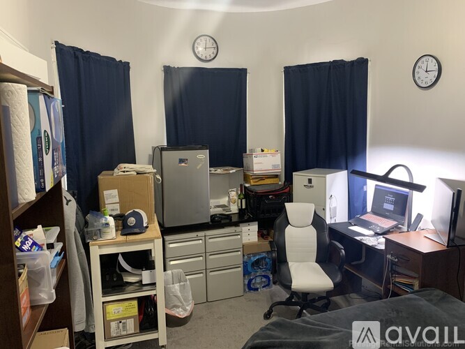 A room with a bed, desk, and computer setup.